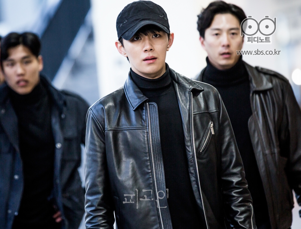 검은 색 옷을 입은 세 명의 남자. 가운데에는 오승훈