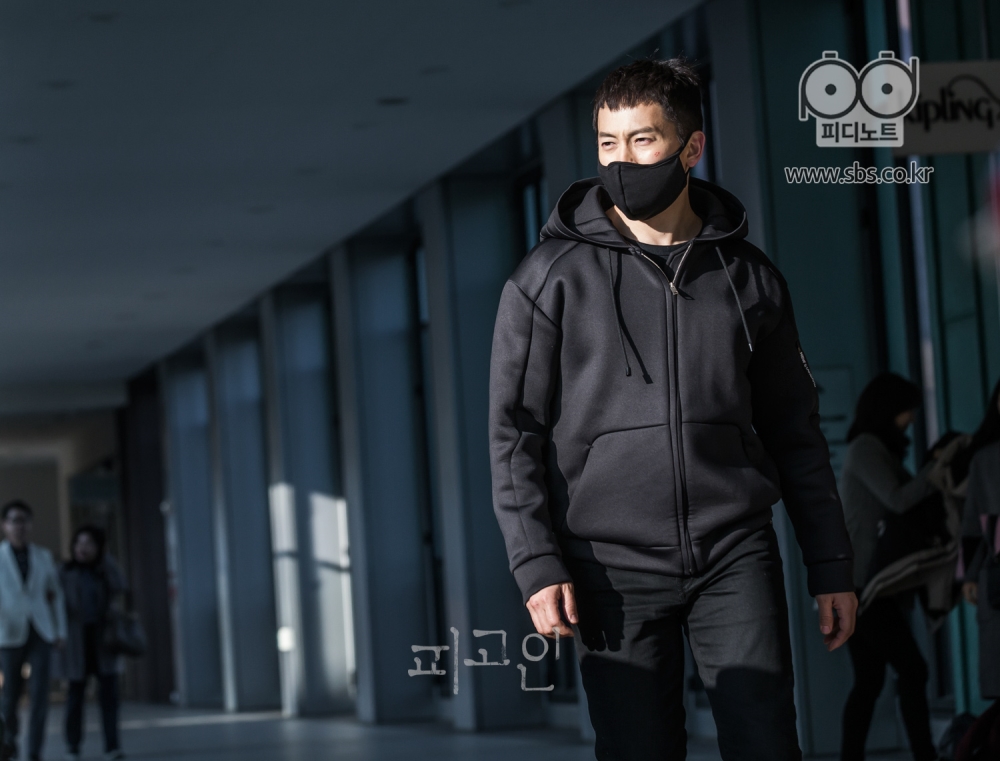 쇼핑몰 복도를 배경으로 온통 검은색으로 옷을 입은 지성이 걸어가는 중이다