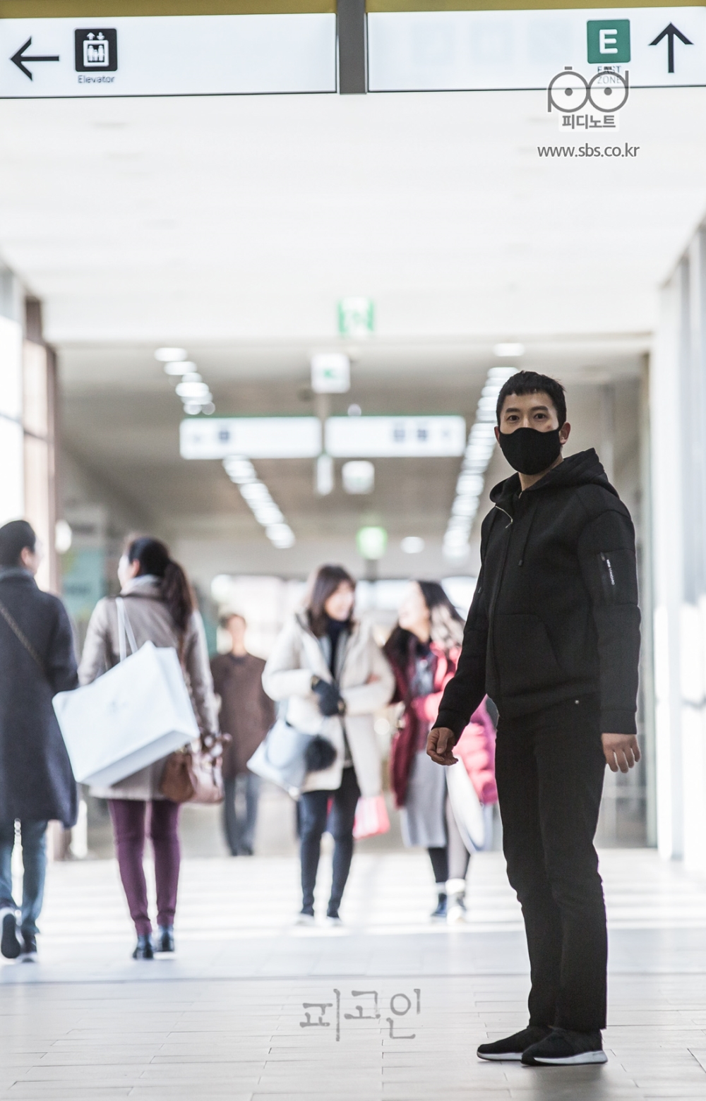 쇼핑몰 인파 가운데 지성이 서 있다