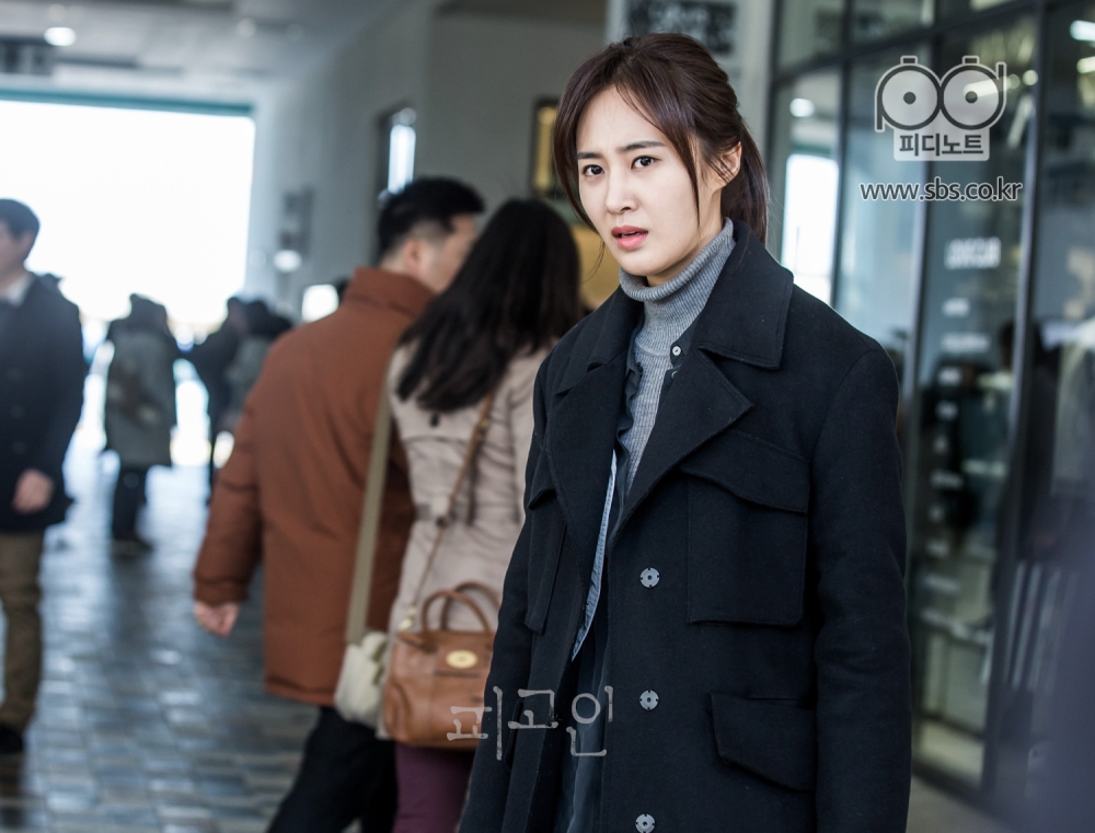 심각한 표정으로 쇼핑몰 한 가운데 서 있는 권유리