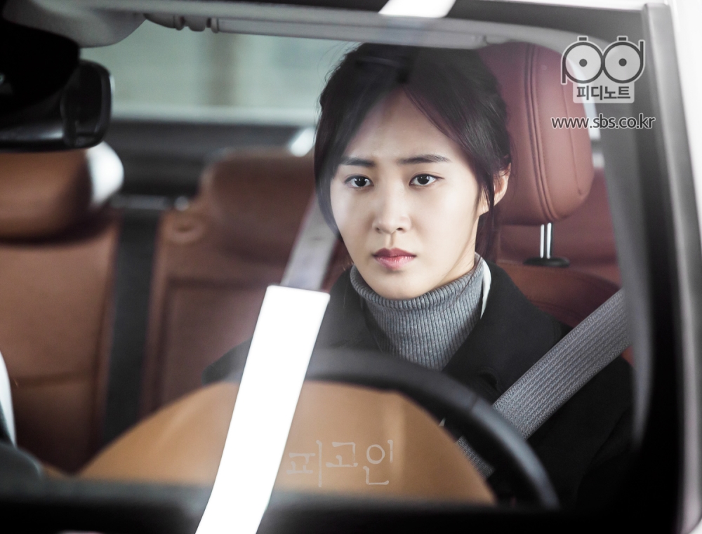 운전석에 심각한 표정으로 앉아 있는 권유리