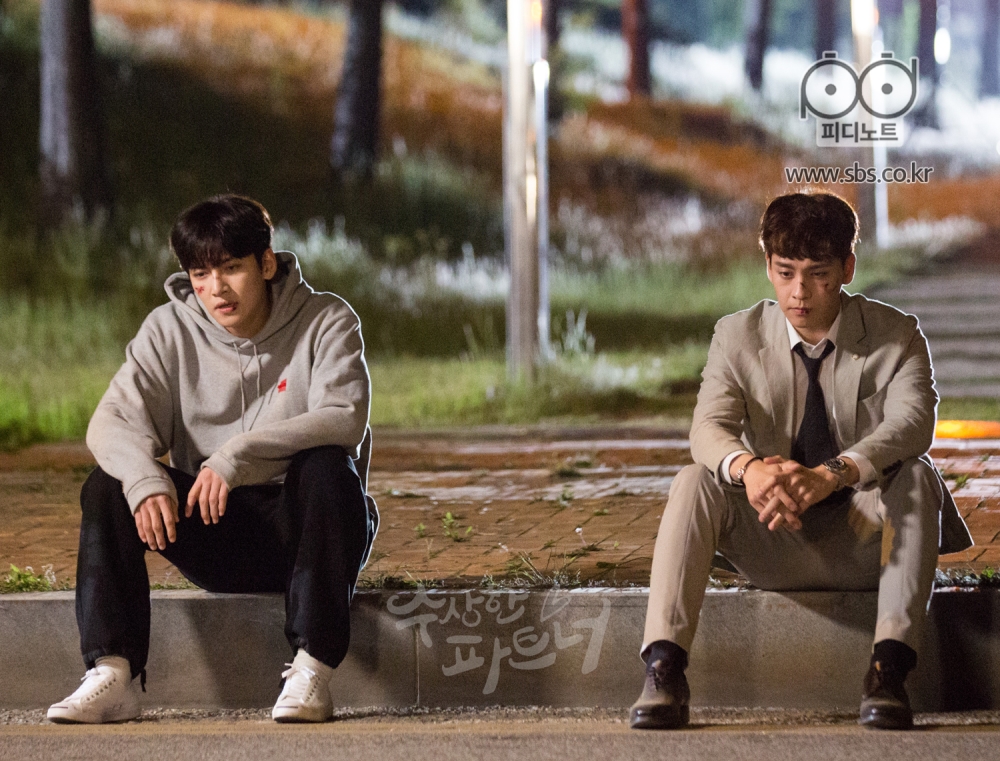 보도 바닥에 걸터 앉은 지욱과 은혁. 얼굴에 상처들이 가득하다.