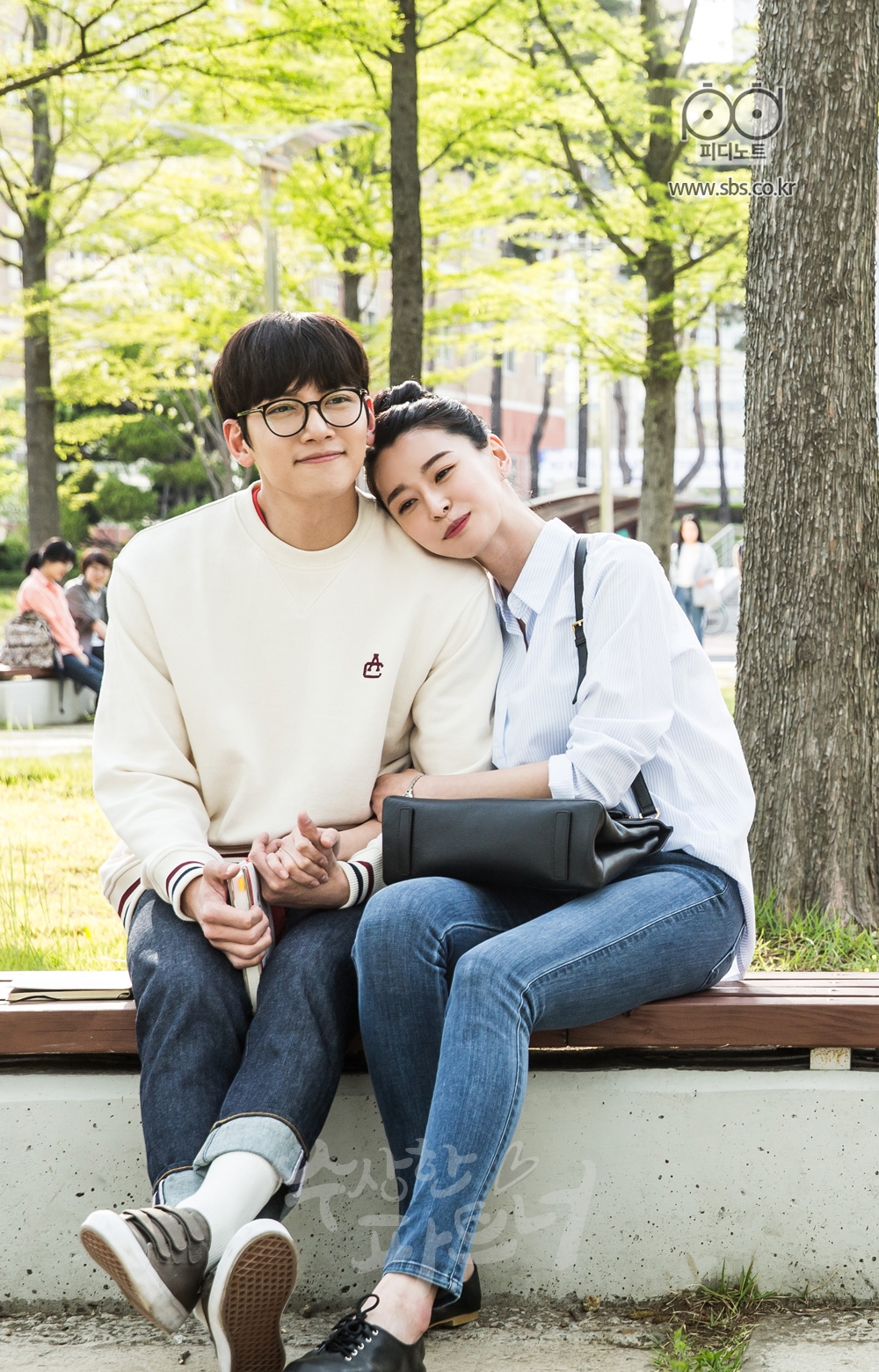 대학교 교정 안에 있는 벤치에 앉아 팔짱끼고 있는 지욱과 유정. 유정이 지욱의 어깨에 기대어 있다.