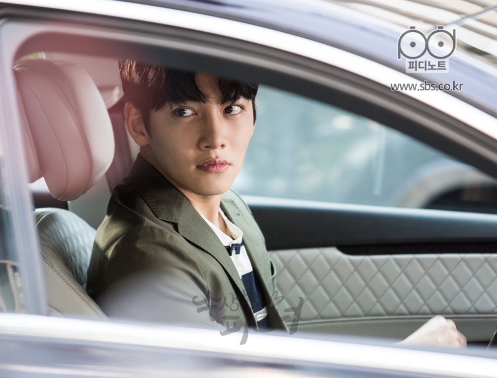 차 운전석에 앉아 봉희를 기다리고 있던 지욱. 조수석 창밖으로 봉희가 나온 것을 보고 있다.