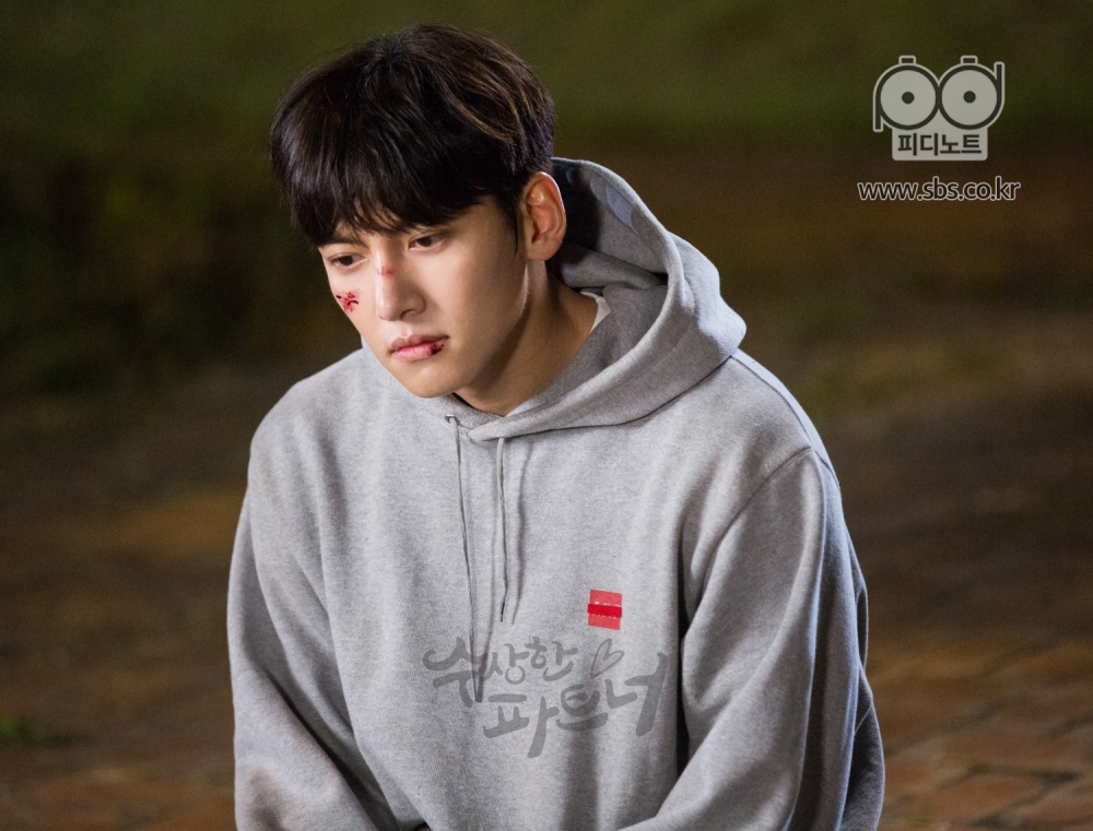 은혁의 옆에 같이 앉아 슬픈 듯 담담한 표정의 지욱. 지욱의 얼굴에도 상처가 많이 있다.